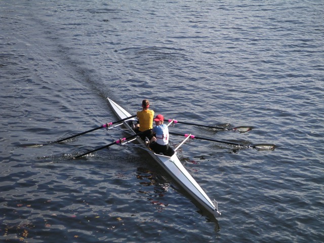 2 persons in rowing shell on water